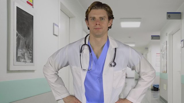 Serious medical pro hands on hips in a hallway