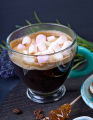 Coffee cup with sugar and spices on a wooden board.