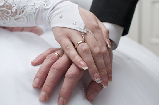 Bride and groom are holding hand to hand