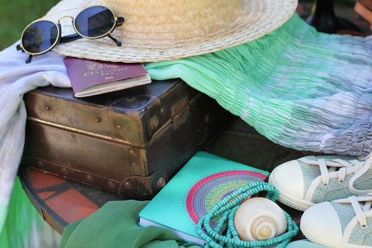 Travel preparations on a table, retro suitcase with women summer outfit