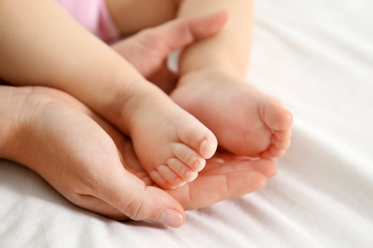 Woman holding baby feet