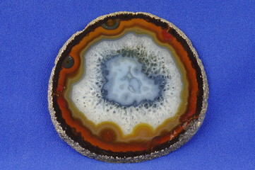 A cross section of the agate stone on a blue background. Origin: Brazil.