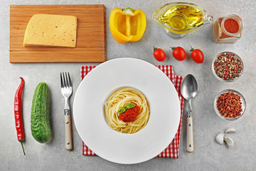 Fototapeta na wymiar Composition of spaghetti in white plate on gray background