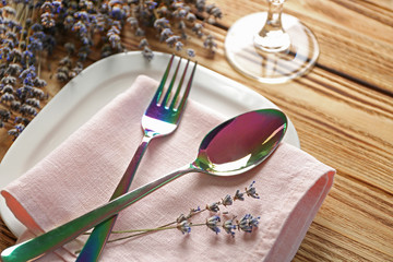 Beautiful table setting with lavender flowers on wooden background