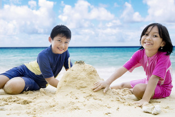 Happy children making sandcastle