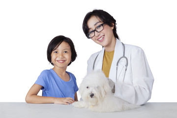 Little girl and puppy visiting veterinarian