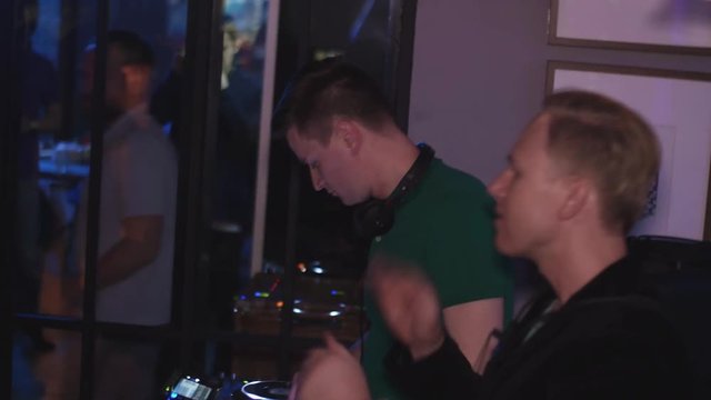 Dj spinning at turntable. Man with saxophone clap in hands. Party in nightclub. Holidays