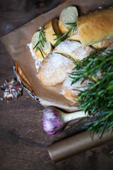 Homemade baguette with Rosemary on rustic wooden background