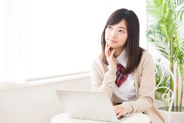asian schoolgirl using laptop in the cafe