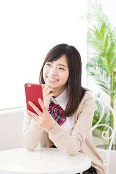 asian schoolgirl using smart phone in the cafe
