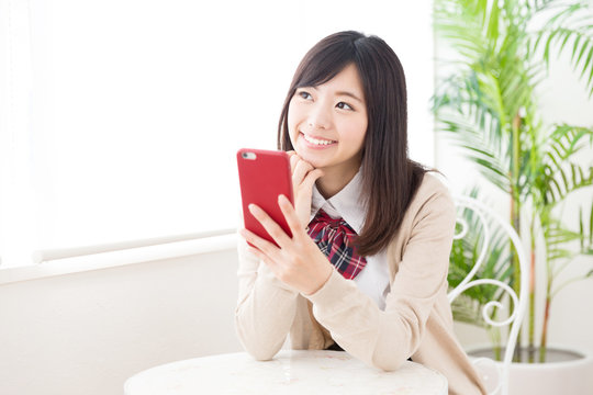 asian schoolgirl using smart phone in the cafe