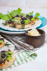 Crostini with fish with olives, cheese and chives