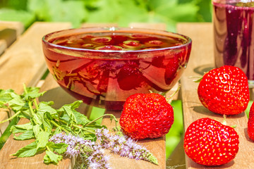 Strawberries, jam, juice on the table in the garden