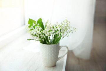 Bouquet of lilies of the valley on windowsill