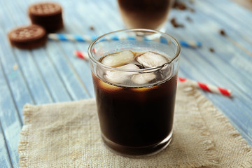 Glass of iced coffee on wooden background