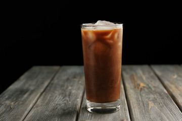 Glass of iced coffee on wooden table