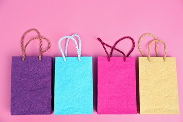 Paper shopping bags on pink background