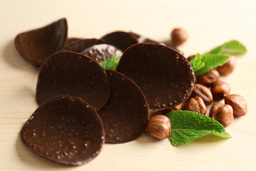 Chocolate chips with hazelnuts and mint leaves on wooden background