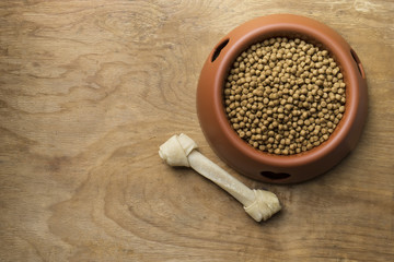 Dog bone and dog food on wood table
