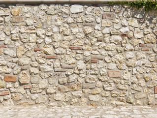 Picturesque stone wall in a bright sunny day as background
