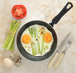 scrambled eggs in a frying pan with asparagus