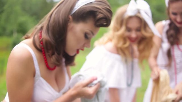women wash using a old fashioned washboard 