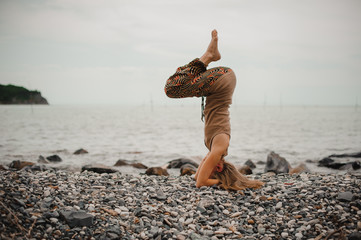 woman standing on her head doing yoga