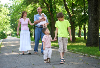 Obraz premium happy family walking in city park, group of five people, summer season, child and parent