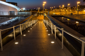 Fototapeta na wymiar lighted walkway with a fountain on each side