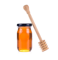 Glass jar full of honey wooden honey dipper
