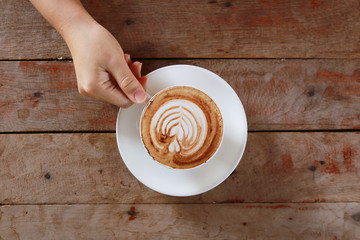woman hand holding cup of coffee while resting in the cafe,top v