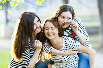Three similar to each other sisters girls hugging. Group of frie
