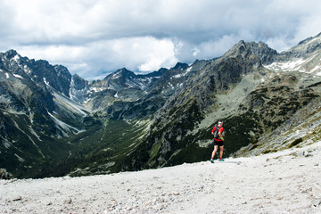 ultra trail runner training for fitness in high mountain scenery with peak view