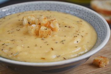 Bowl of zucchini and cauliflower cream soup on wooden table. Hea