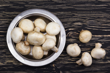 Champignon in the bowl on the old table.