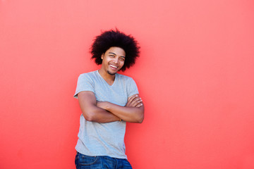 Confident young man with afro smiling with arms crossed