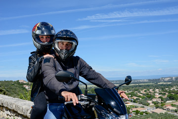 Fototapeta na wymiar happy young biker couple riding their motorbike in summer