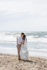 Fototapeta na wymiar Cheerful wedding couple on the beach