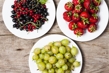Summer berries on a wooden table.Goosbery, strawberry,black, red
