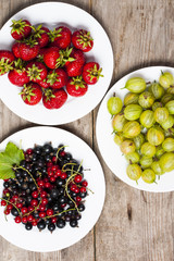 Summer berries on a wooden table.Goosbery, strawberry,black, red