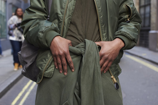 Midsection Of Man Wearing Olive Green Clothes Standing On Street