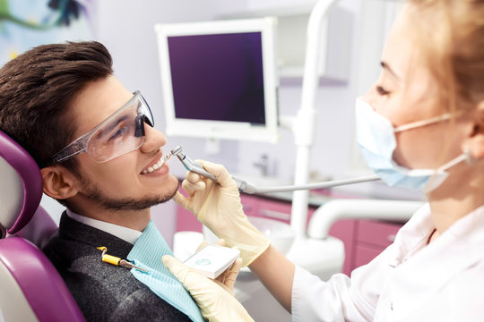 Overview of dental caries prevention.man at the dentist's chair during a dental procedure. Beautiful man smile close up. Healthy Smile. Beautiful male Smile

