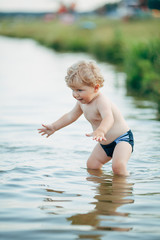 little funny boy playing in water