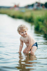 little funny boy playing in water