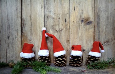 Rustikaler weihnachtlicher Hintergrund - Grußkarte - kleine Weihnachtsmützen