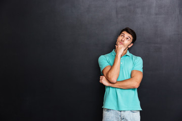 Pensive young man standing and thinking
