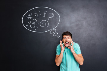 Crazy furious man yelling over blackboard background with speech bubble