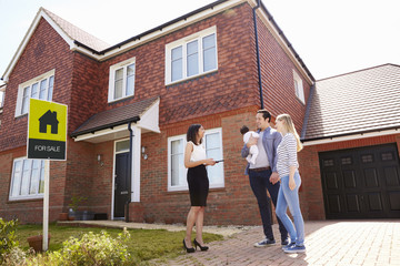 Realtor Outside House For Sale With Young Family