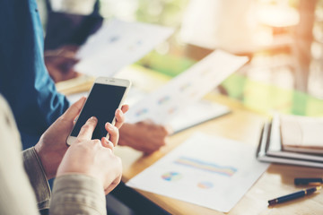 Woman hand typing text at phone with work at office.
