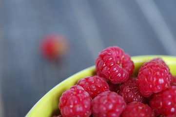 Juicy mature berries of raspberry in a plate close up. 